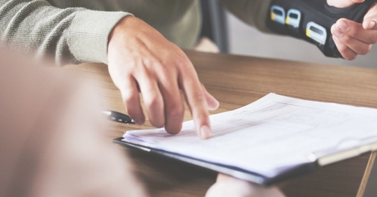 Injured man pointing to legal documents following a car accident.